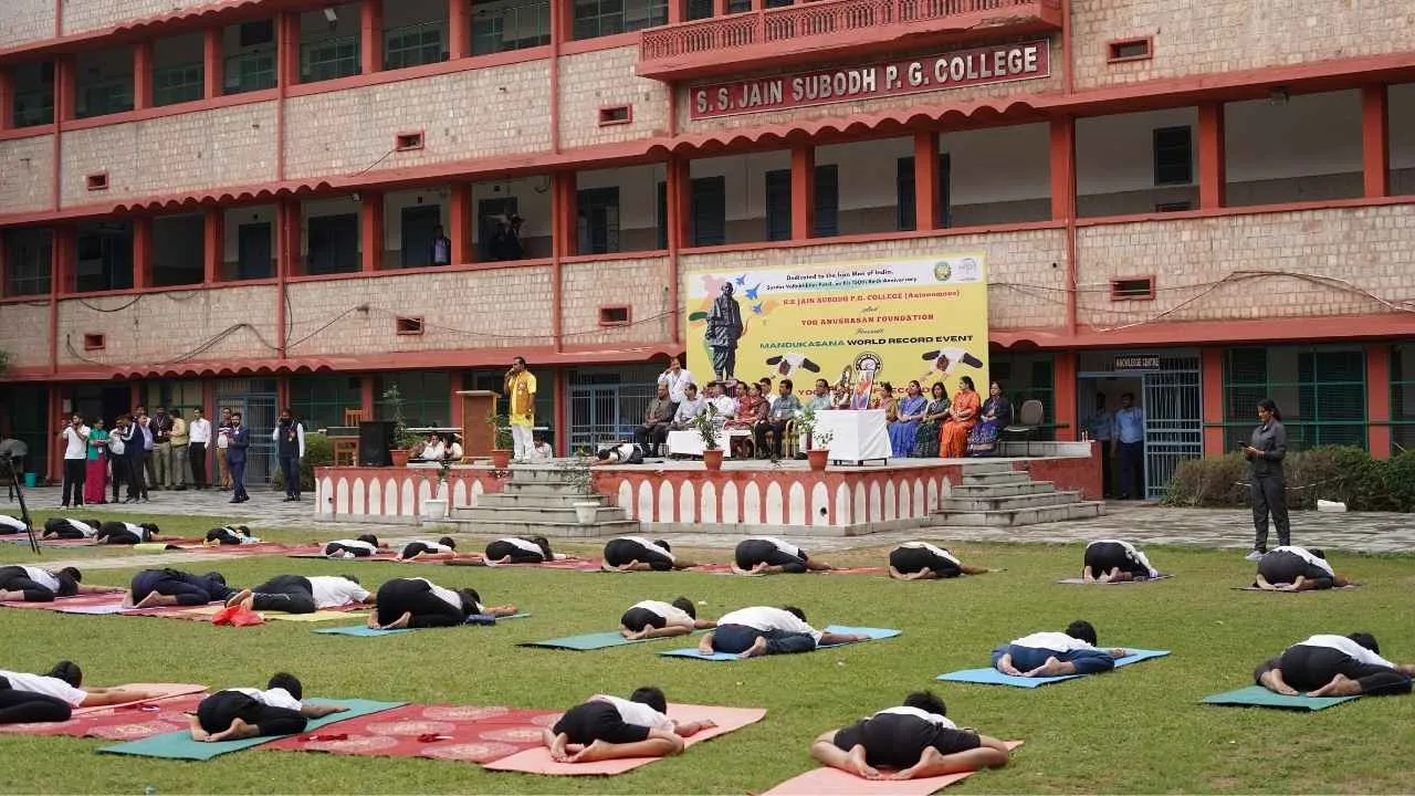 Participants performing Mandukasana (Frog Pose) for the Longest Group Performance, a Group Yoga World Record record attempt for Yoga Book of Records at S.S. Jain Subodh P.G. College